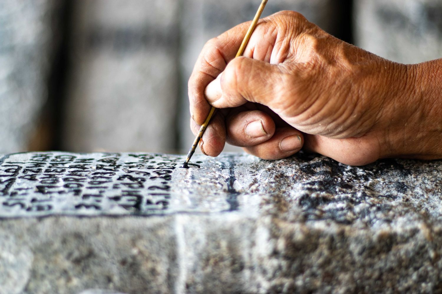 The final step entails using a stick to paint the stone with Chinese ink