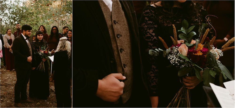 A wedding ceremony takes place in a wooded area during autumn with guests gathered around.