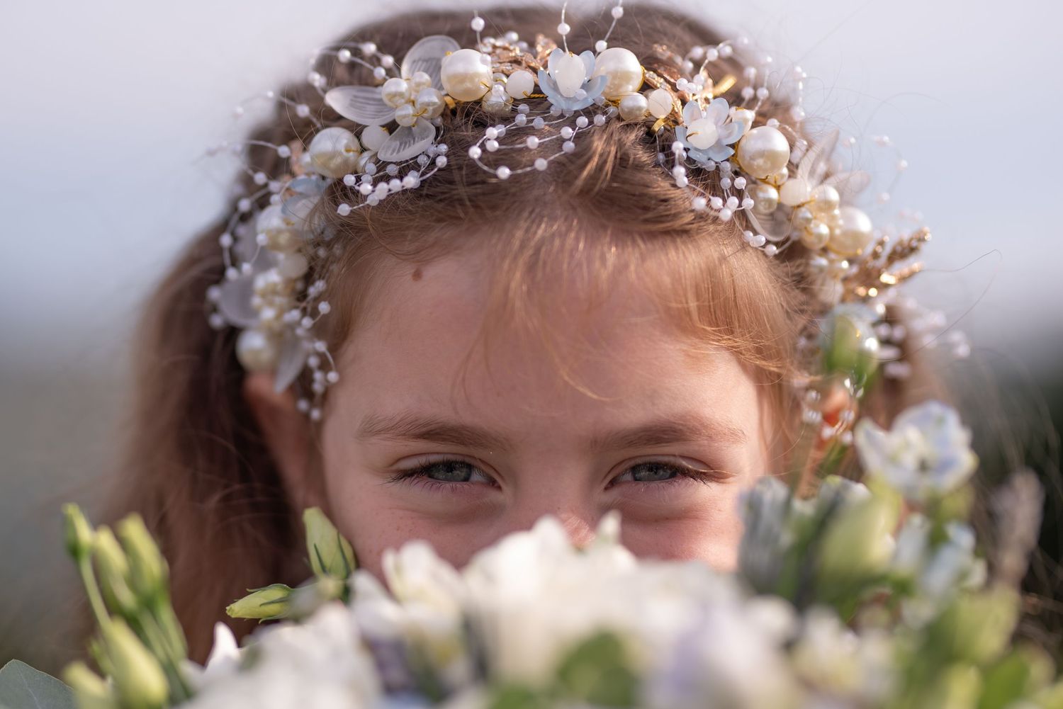 Delicate white floral crown worn at an outdoor celebration.