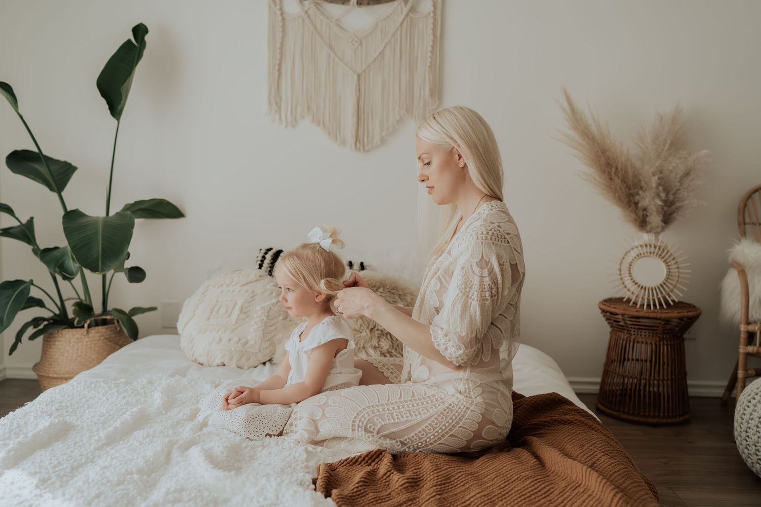 A cozy white bedroom scene with plants and natural decor elements creating a peaceful atmosphere.