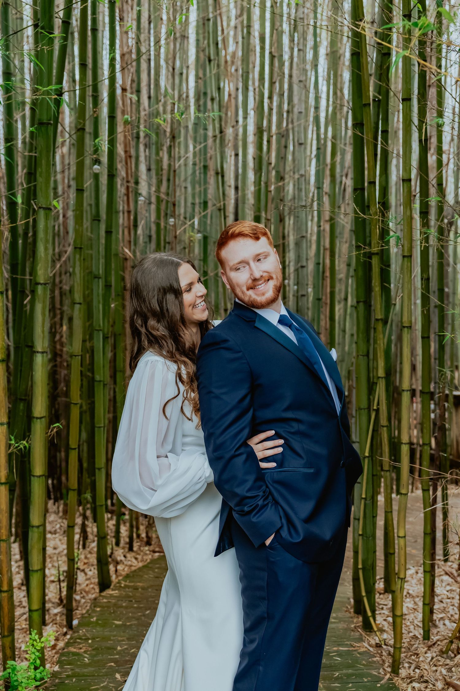 A romantic photoshoot among tall bamboo trees creating a serene forest backdrop.