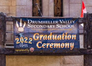 Drumheller Valley Secondary School 2022 graduation ceremony banner on stone wall.