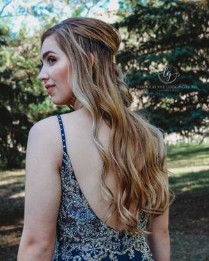 Elegant evening hairstyle with soft waves cascading down a sparkling formal dress.