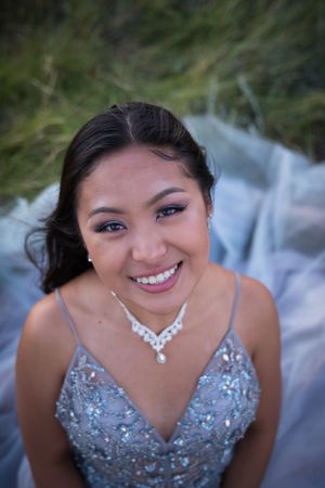 A formal portrait featuring a sparkling silver dress and crystal necklace.