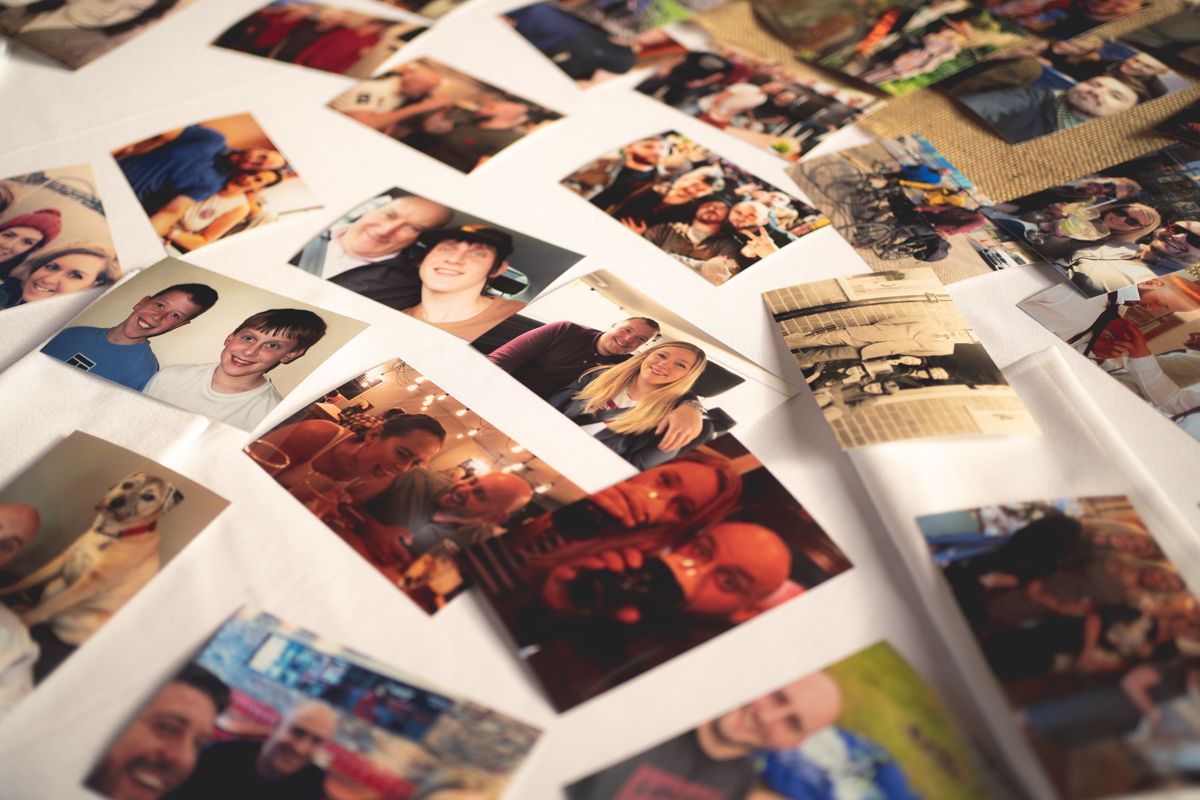 Close-up view of numerous personal photographs spread across a surface.