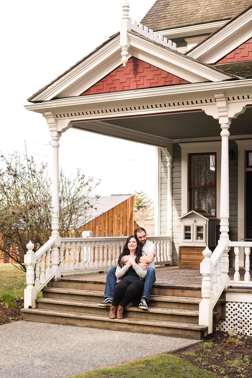 A couple sitting together on the front porch of the Historic Stewart Farmhouse.