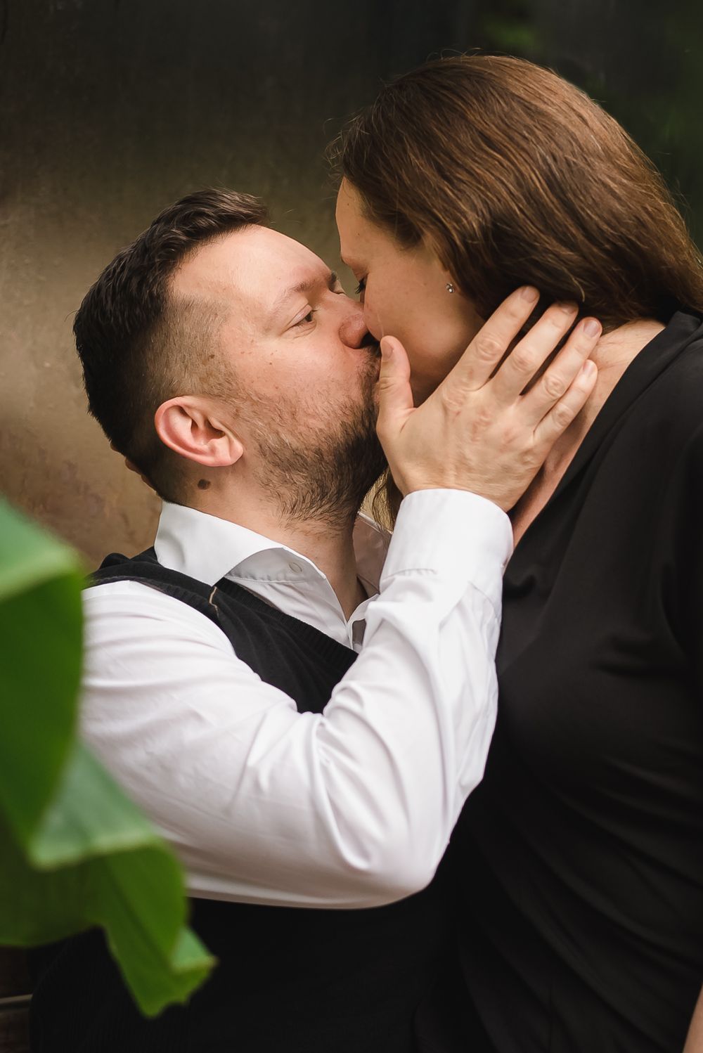 Inside a greenhouse a couple shares a passionate kiss. Sendall Gardens in Langley, BC.