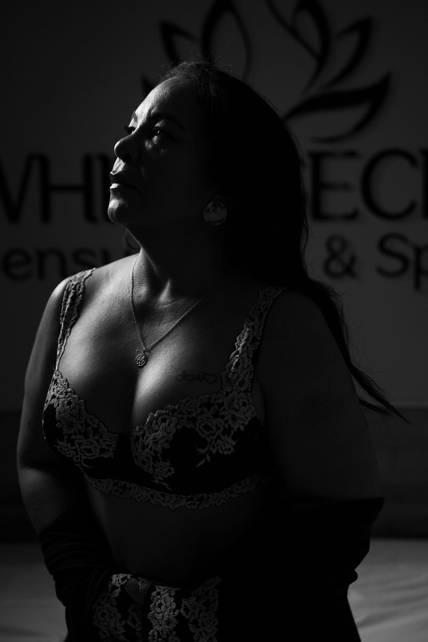 Artistic black and white boudoir photography with dramatic lighting and shadows.