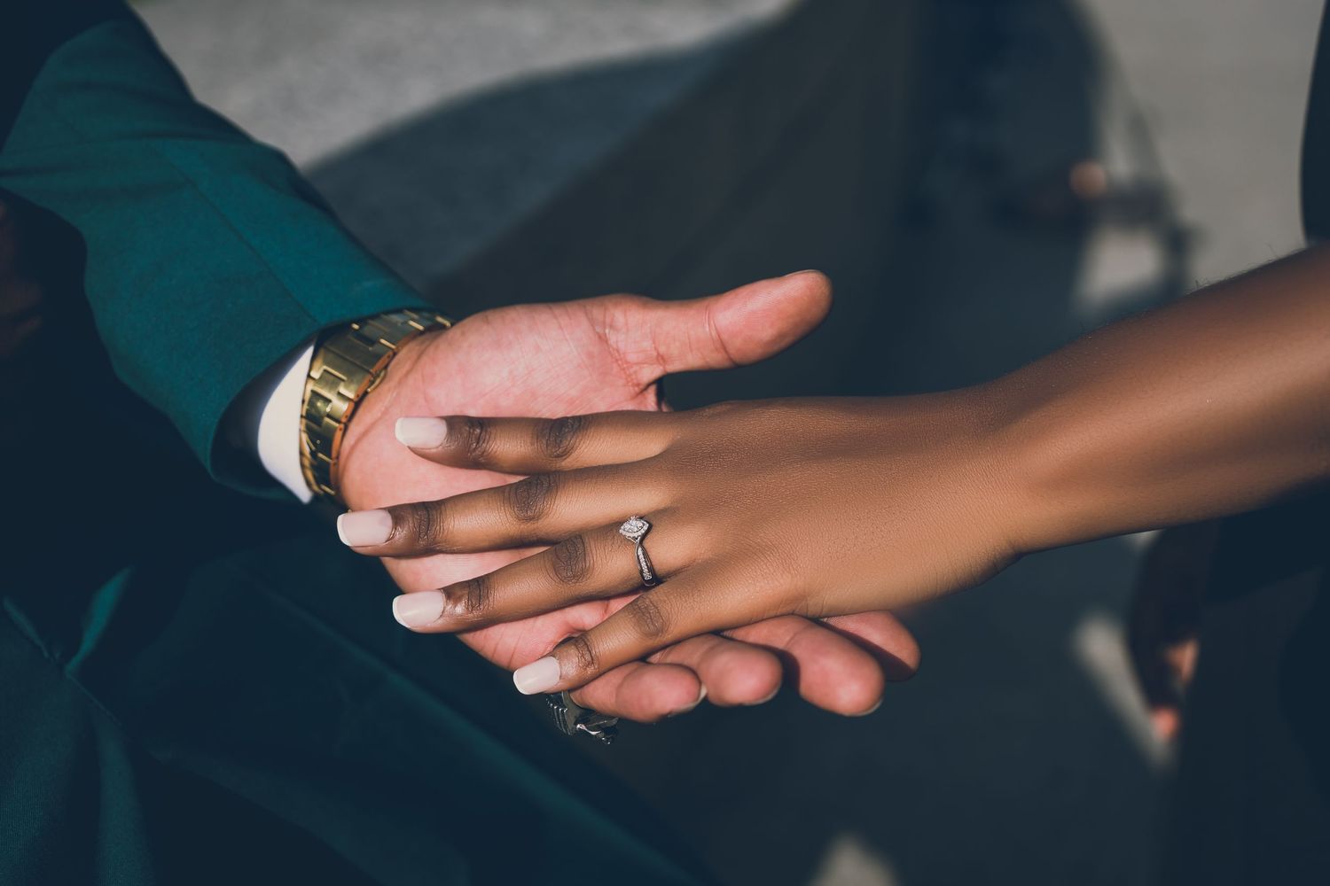 Close-up of hands displaying engagement ring and bracelet.
