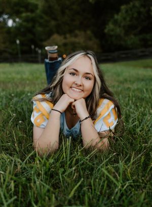 Relaxed outdoor portrait laying in green grass field.