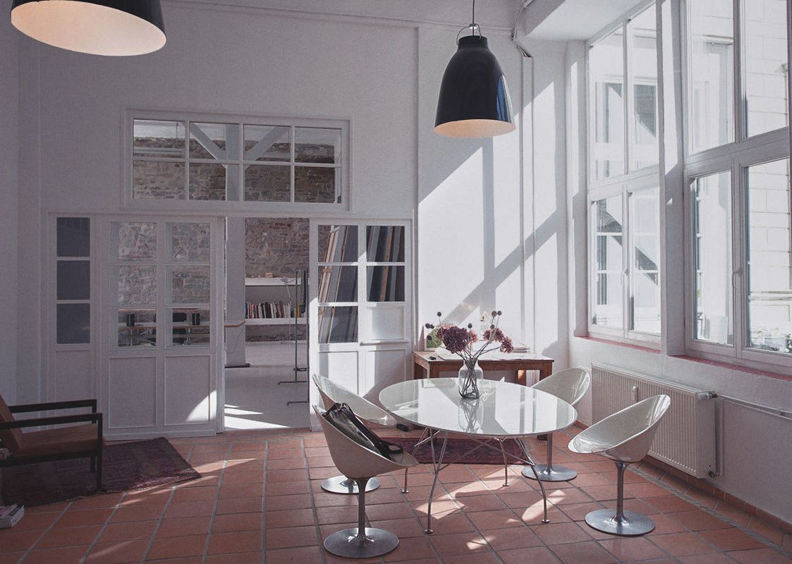 Stilmix: große Caravaggio Industrielampen und der moderne Kartelltisch geben dem Eingangsraum seine Einzigartigkeit