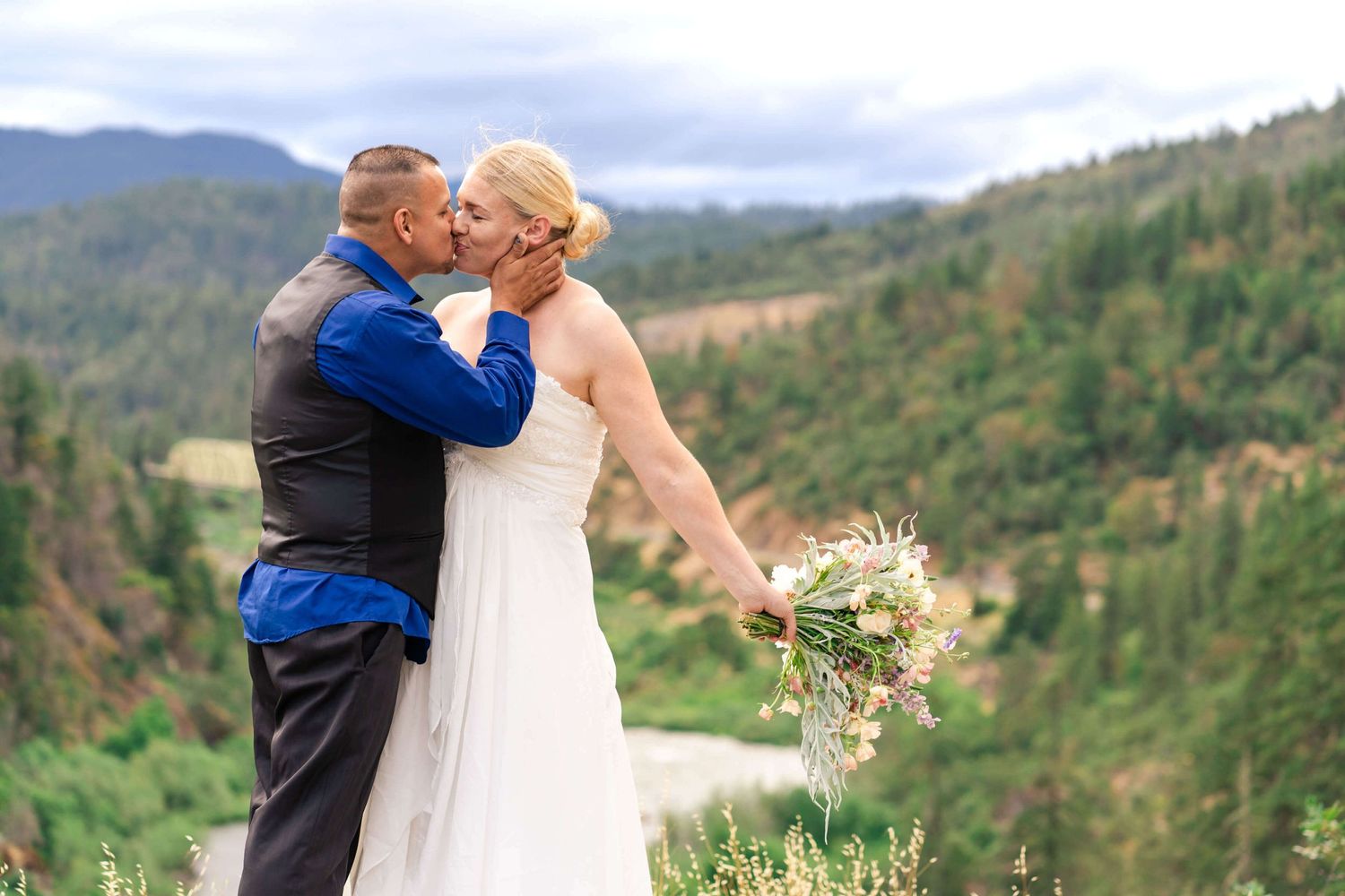 Groom and bride kissing with the Hellgate Canyon in the background