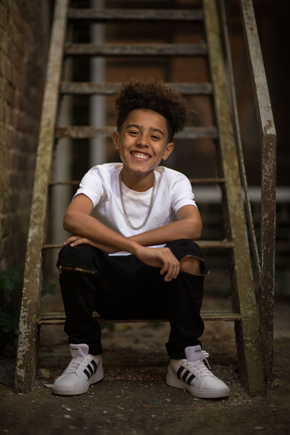 Boy sitting on old stairs