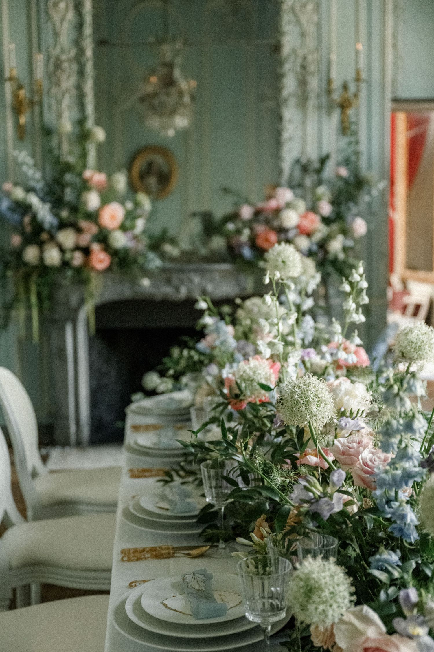Romantic table setting with delicate floral arrangements and place settings in a vintage-style room.