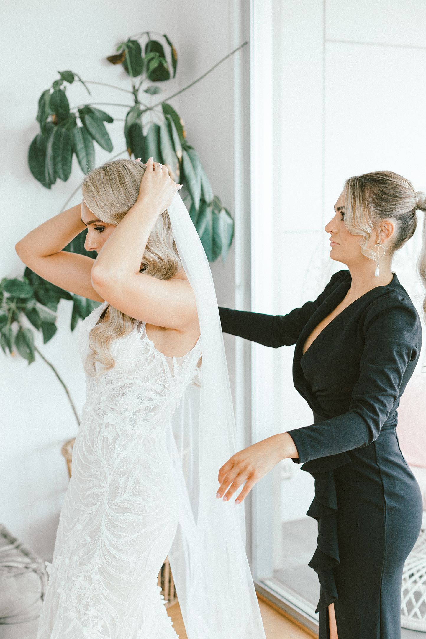 Wedding dress preparations with greenery in background during bridal getting-ready moments.