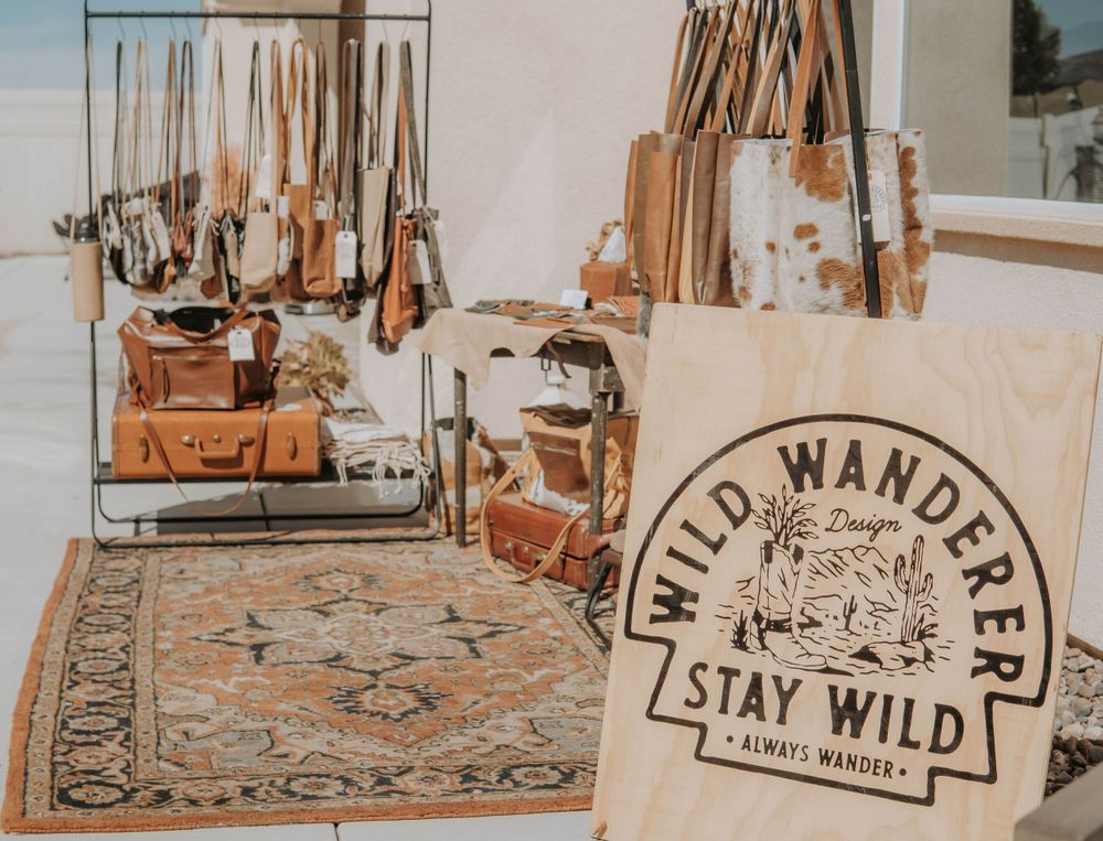 Rustic wooden signs with 'Wild Wander' text displayed in a decorative outdoor setting.