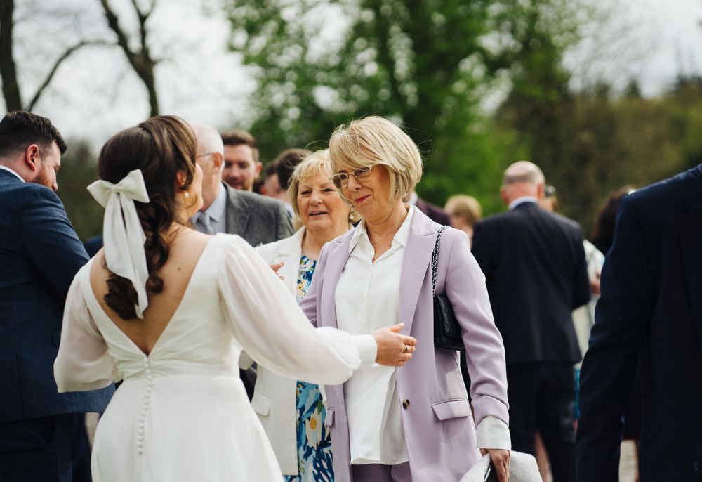 Guests share joyful moments during an outdoor wedding reception on a spring day.