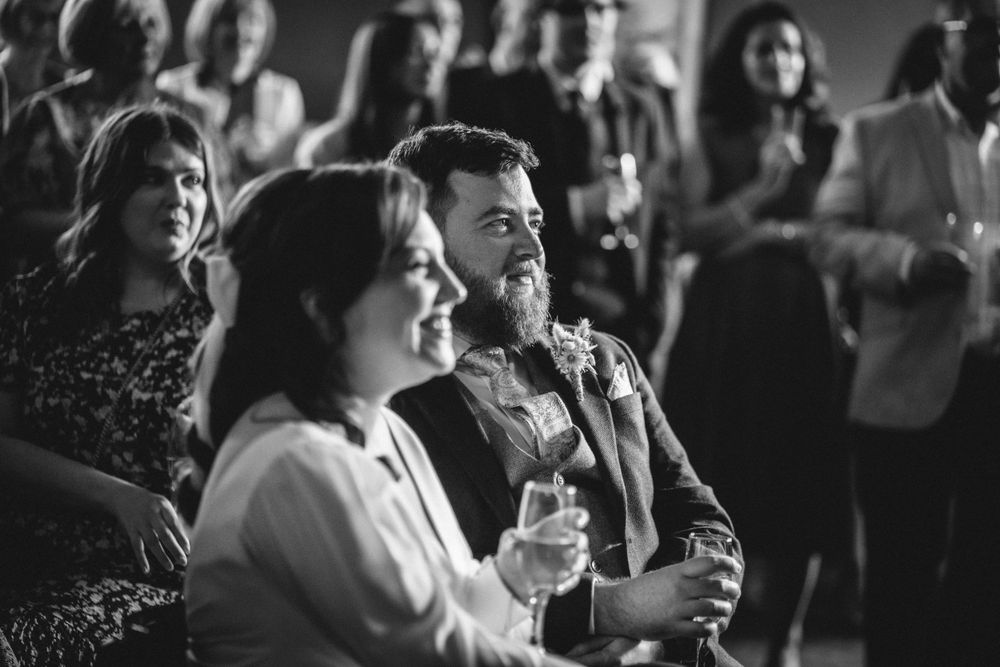 Wedding attendees enjoying drinks and conversation during an indoor reception.