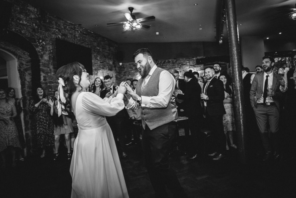Black and white photo of couple sharing their first dance at wedding reception.