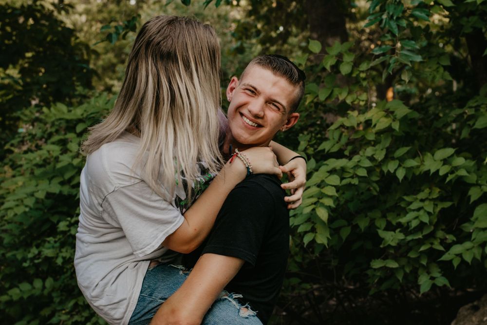 A teen couple enjoying the nice weather and playing outside during senior photos