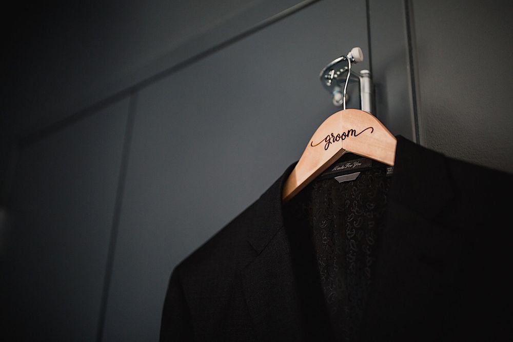 Suit jacket hanging on a hanger that says the groom