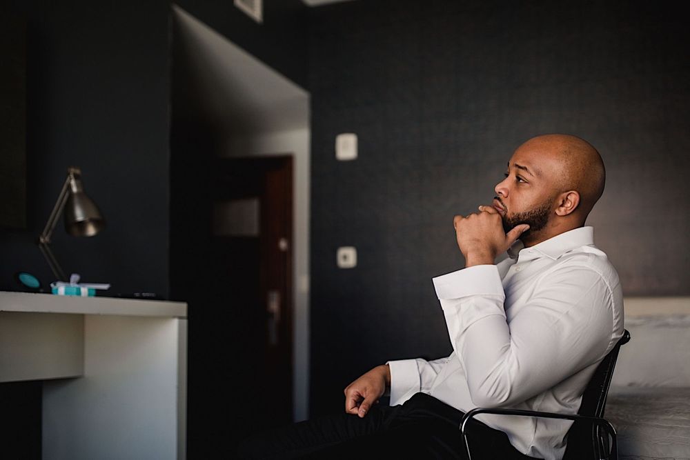 Groom sitting in chair in hotel room in tampa