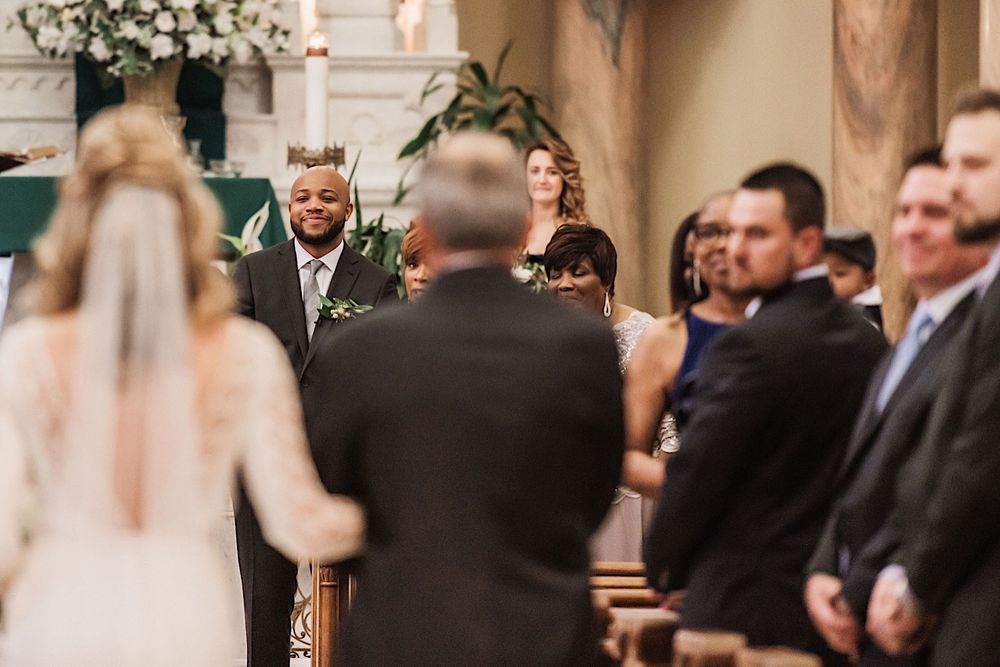 Groom seeing his bride for the first time as she walks down the aisle