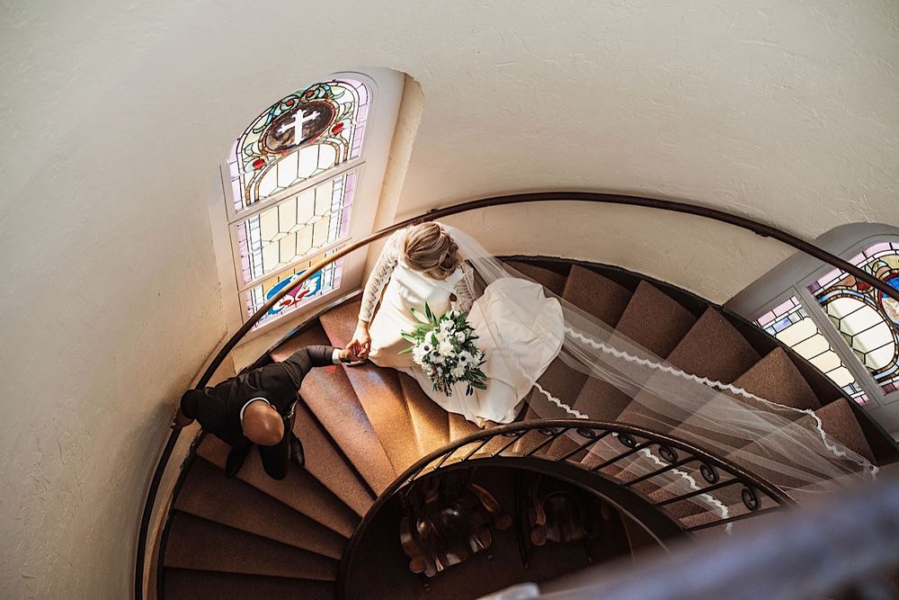 bride and groom walking down the stairs at sacred heart church