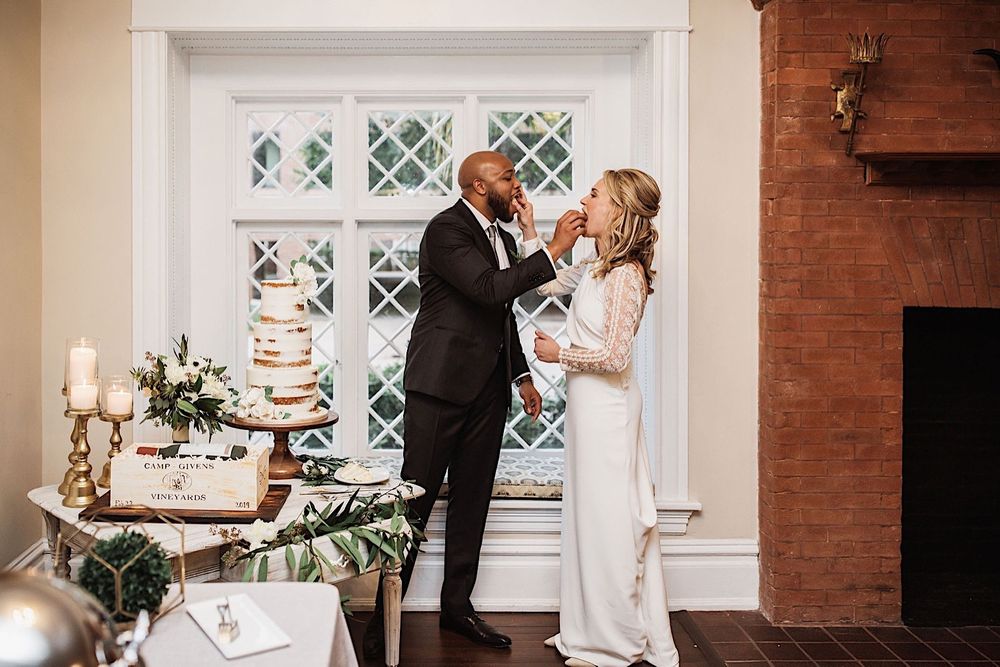 bride and groom feeding each other wedding cake