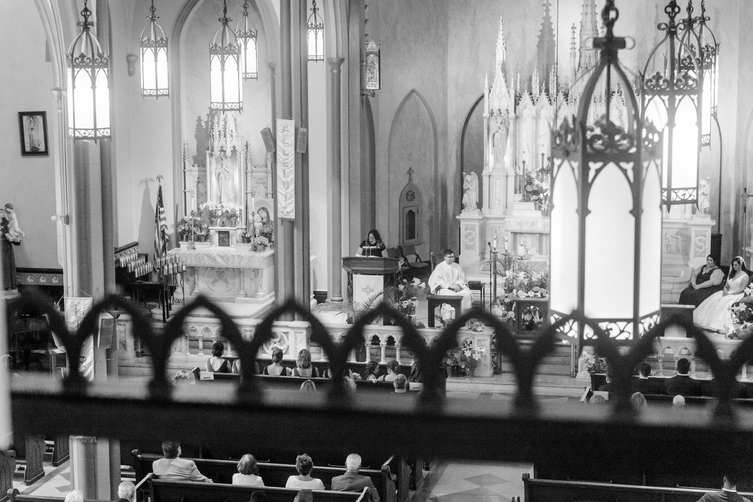 Black and white photo of a traditional church wedding ceremony with Gothic architecture.