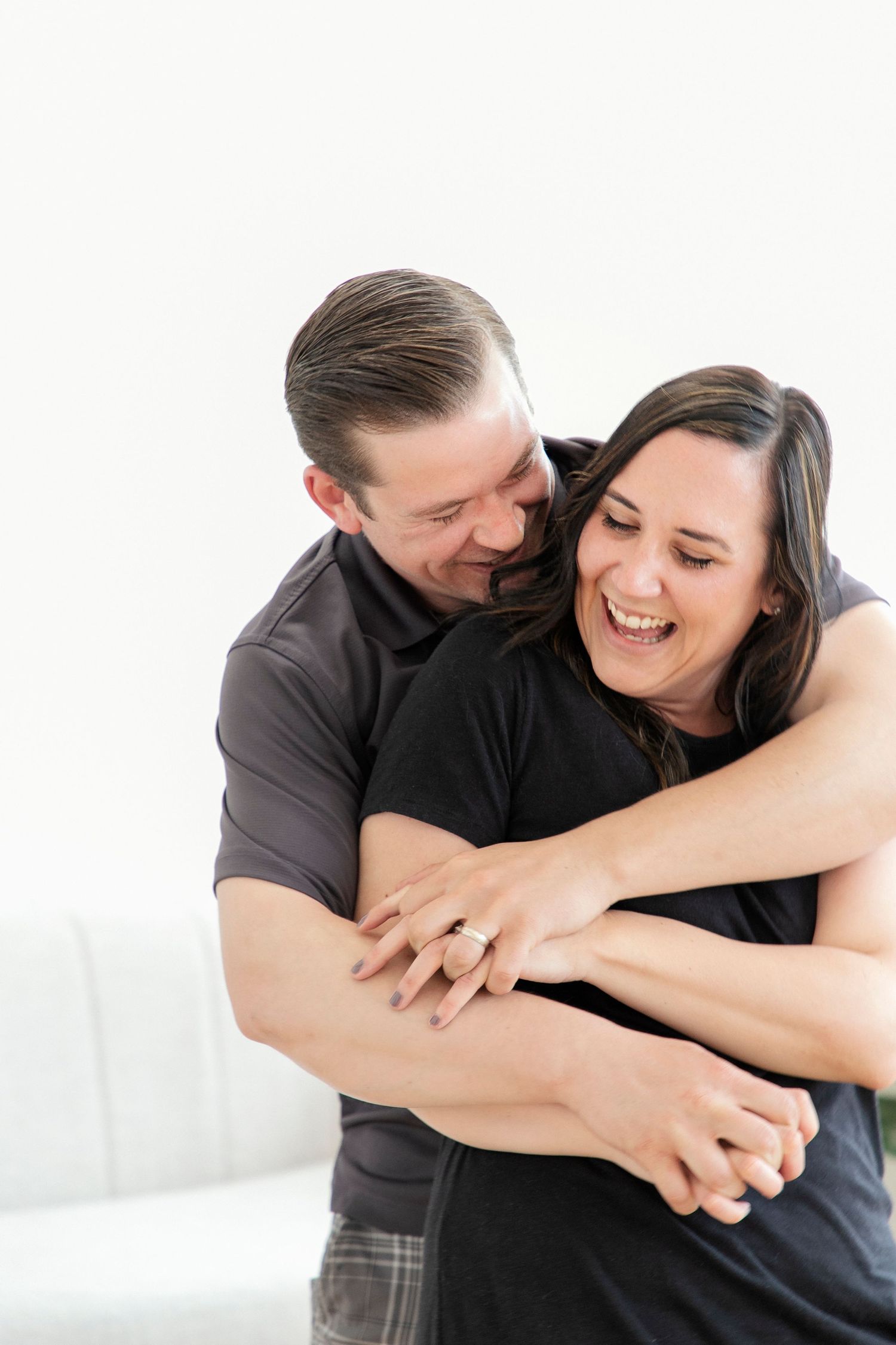 a man "bear hugging" his fiance in a studio