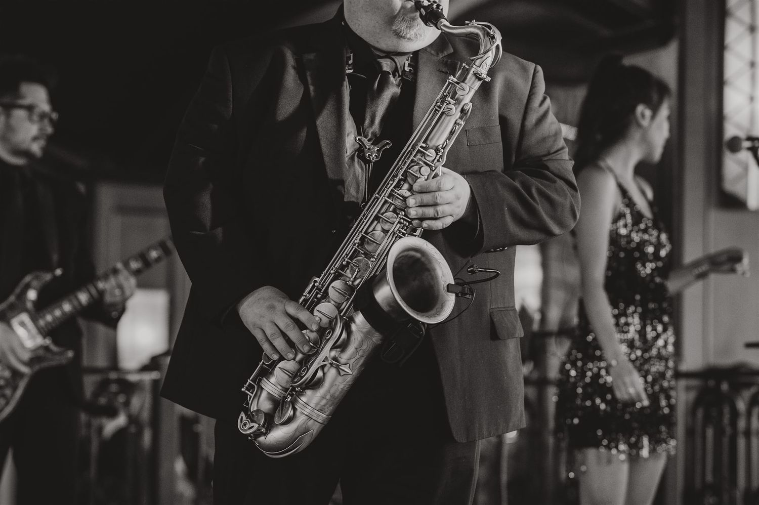 Musician plays saxophone during wedding reception performance.