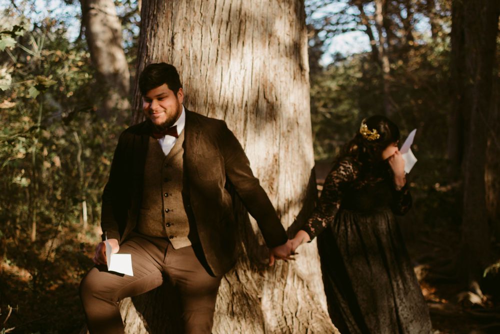 Vintage-style woodland photoshoot featuring two people in Victorian attire posing against a large tree trunk.