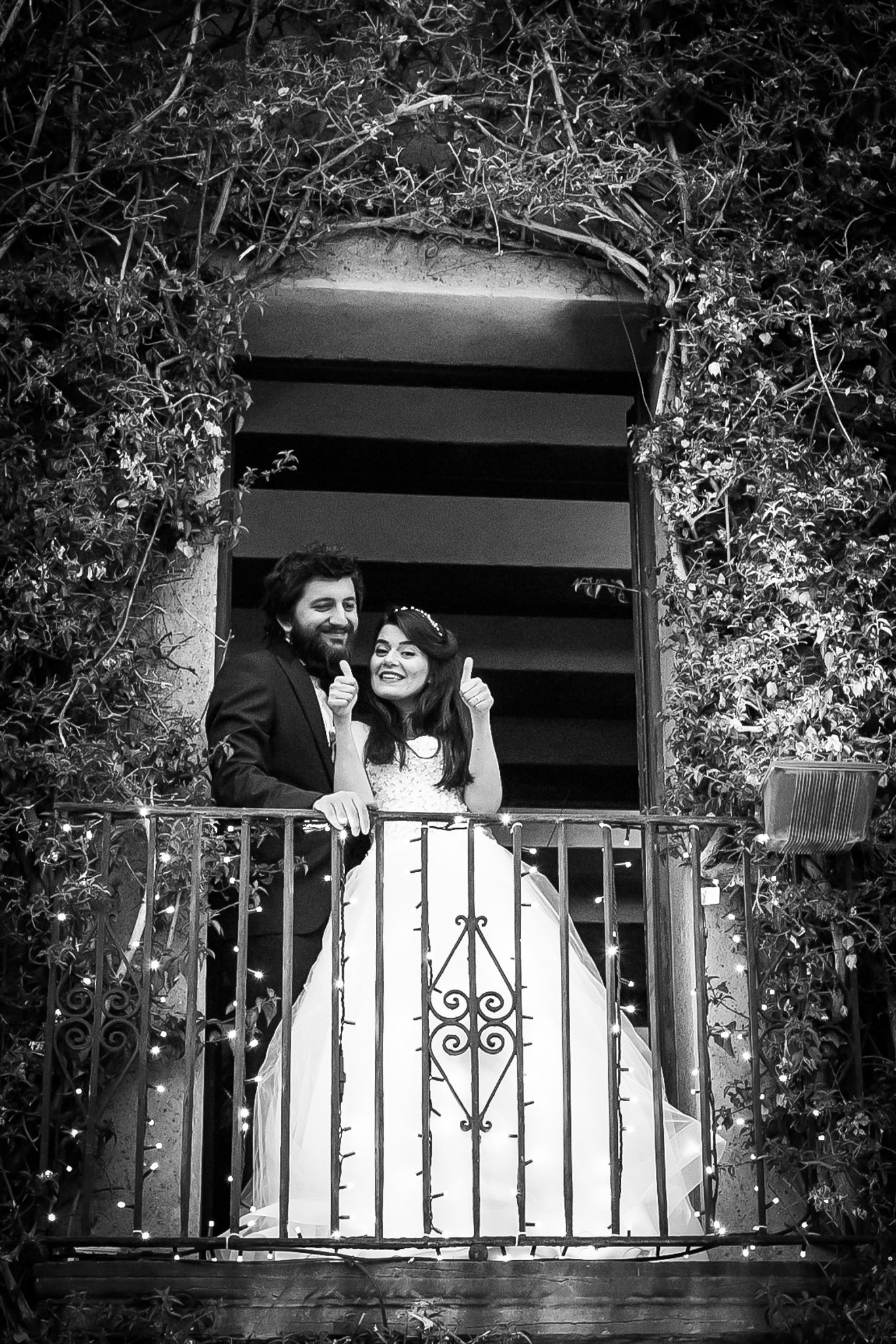 Bride giving thumbs up from the balcony next to the groom