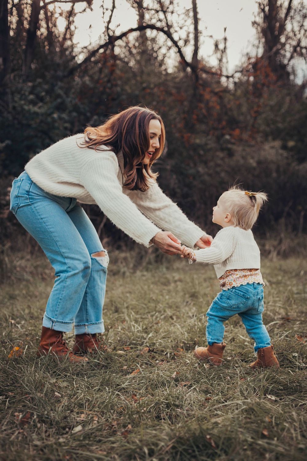 A sweet moment captured between two people holding hands in a rustic outdoor setting.