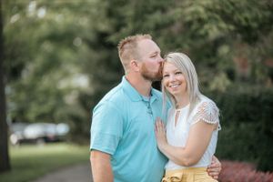 Couple sharing tender moments outdoors during golden hour photoshoot.