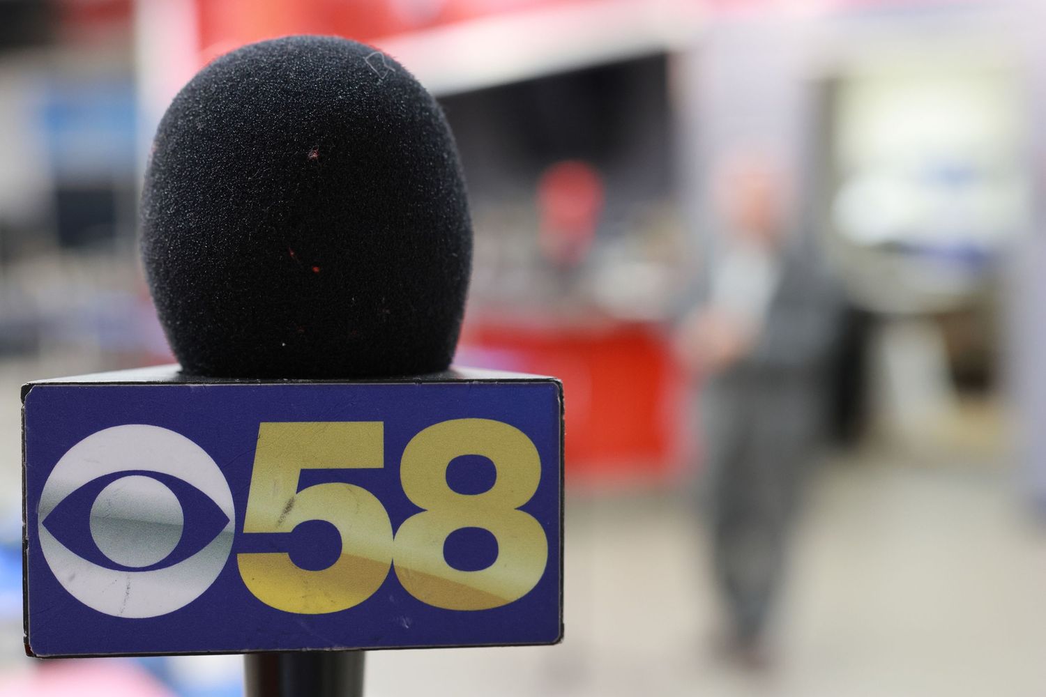 CBS 58 news microphone in focus with blurred background.
