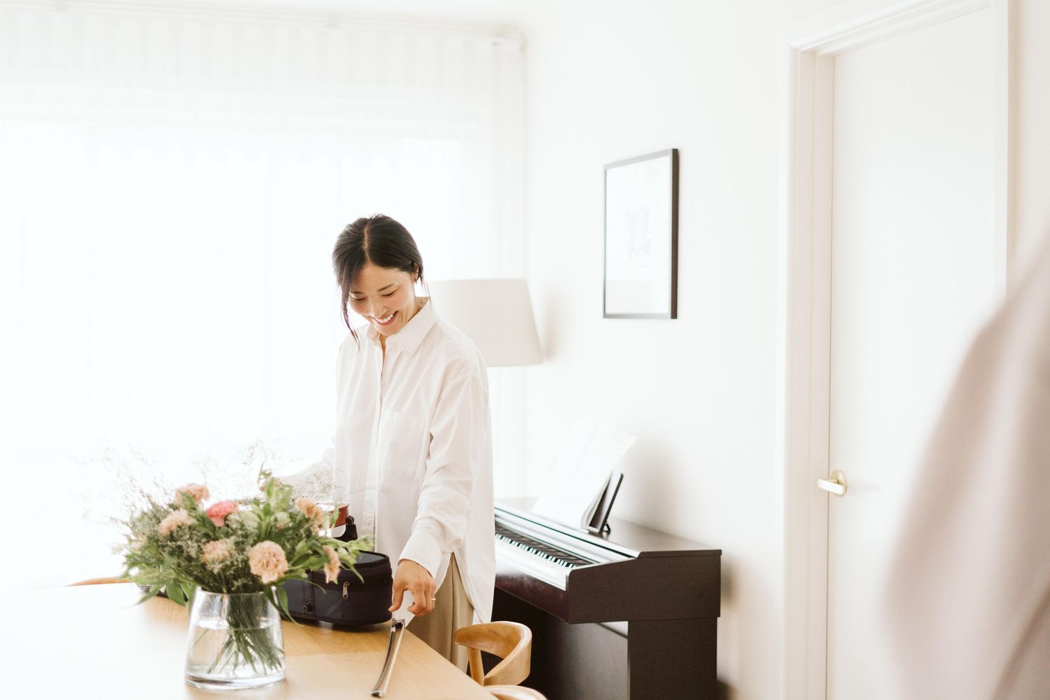 In their North Melbourne home, mom smiling as she is looking at her son's violin.