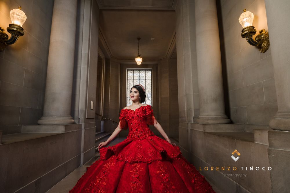 Classic red formal dress captured in architectural hallway with dramatic lighting.