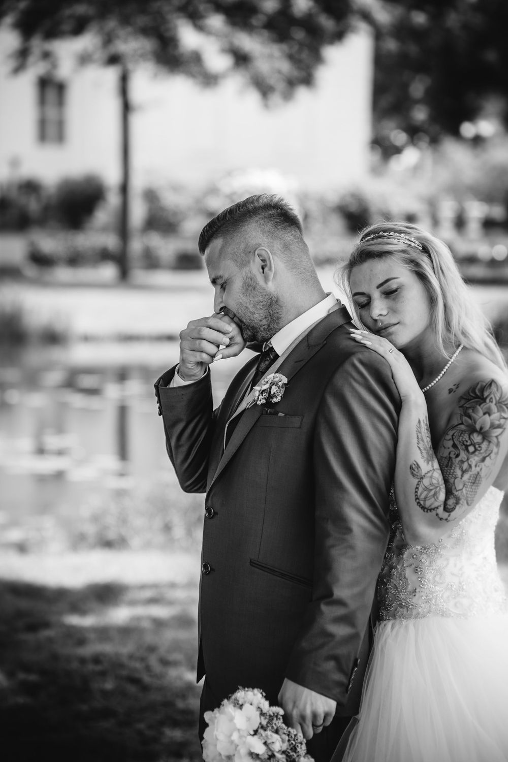 Black and white emotional wedding portrait of a couple in an outdoor setting.