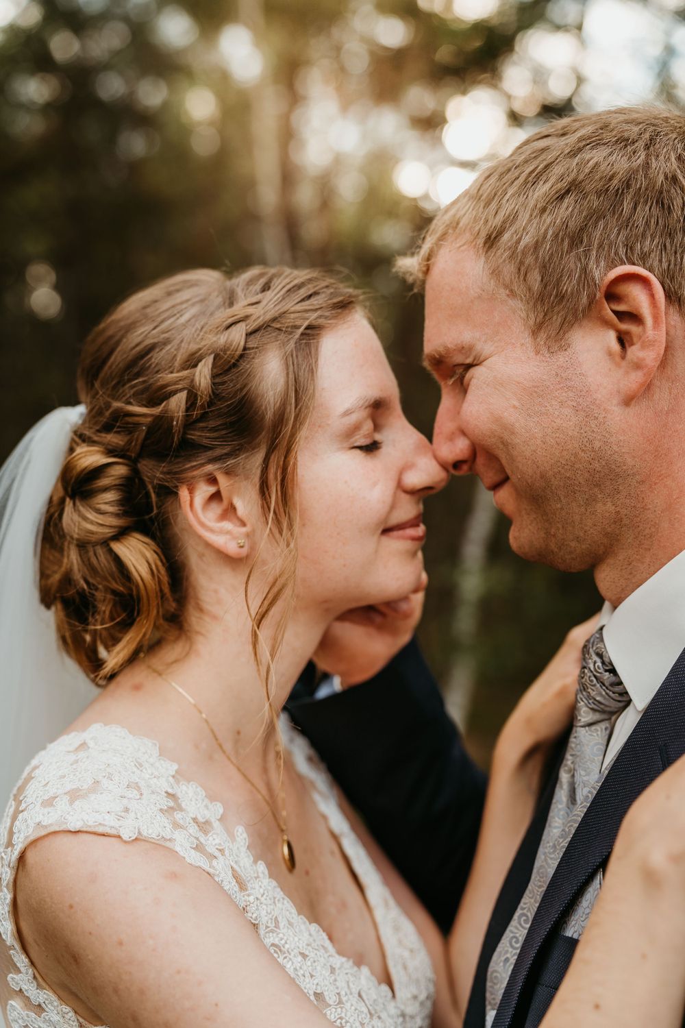 Close-up golden hour wedding portrait showing tender moment between newlyweds.