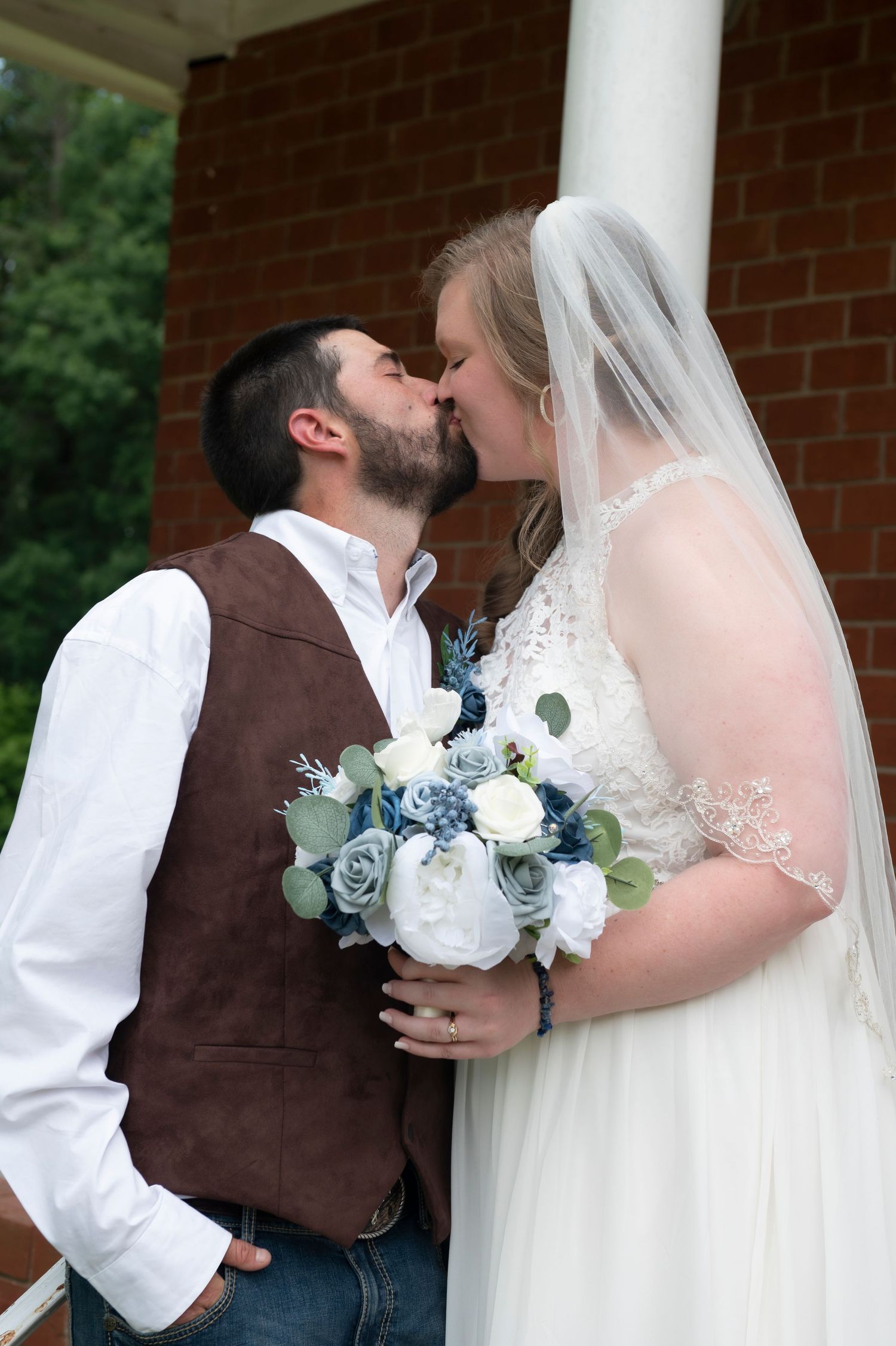 Romantic wedding photos showing couple with white and blue bouquet against brick and column backdrop.