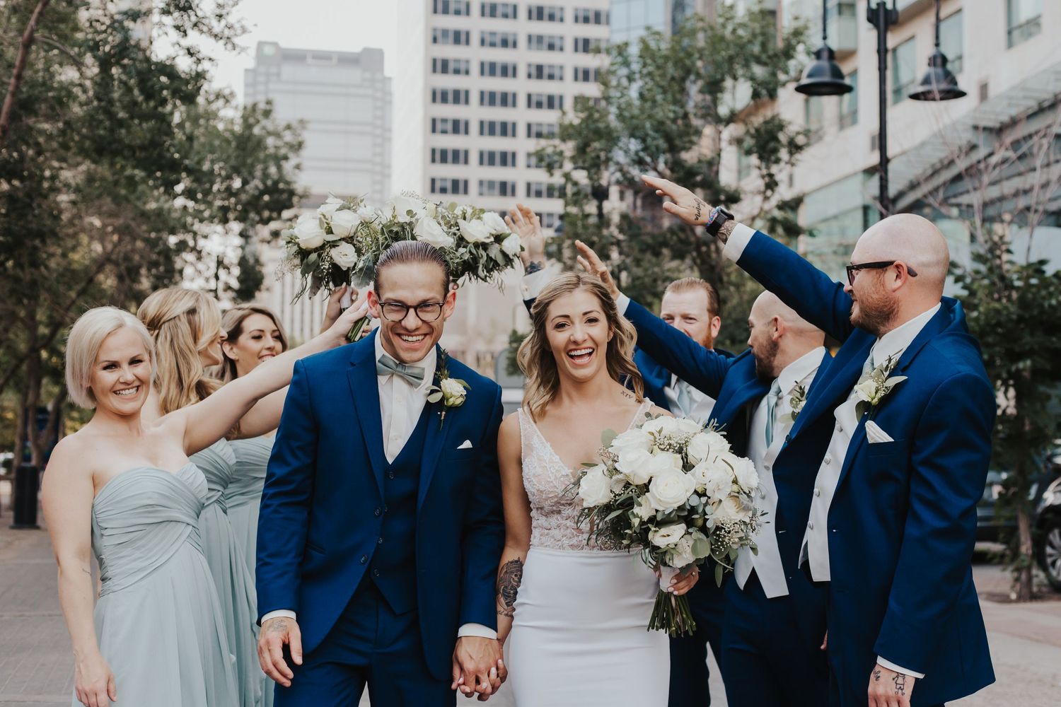Bride and groom smile while with bridal party