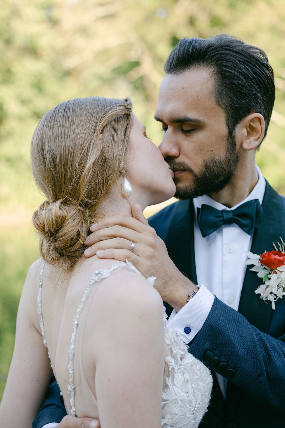 A tender wedding moment captured between a couple with autumn foliage in the background.