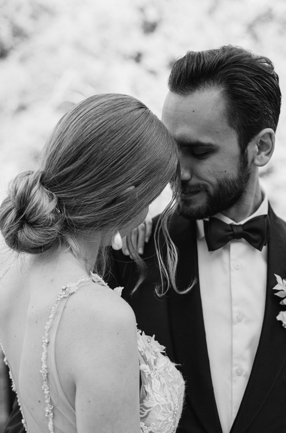 A black and white intimate portrait of newlyweds sharing a close moment.