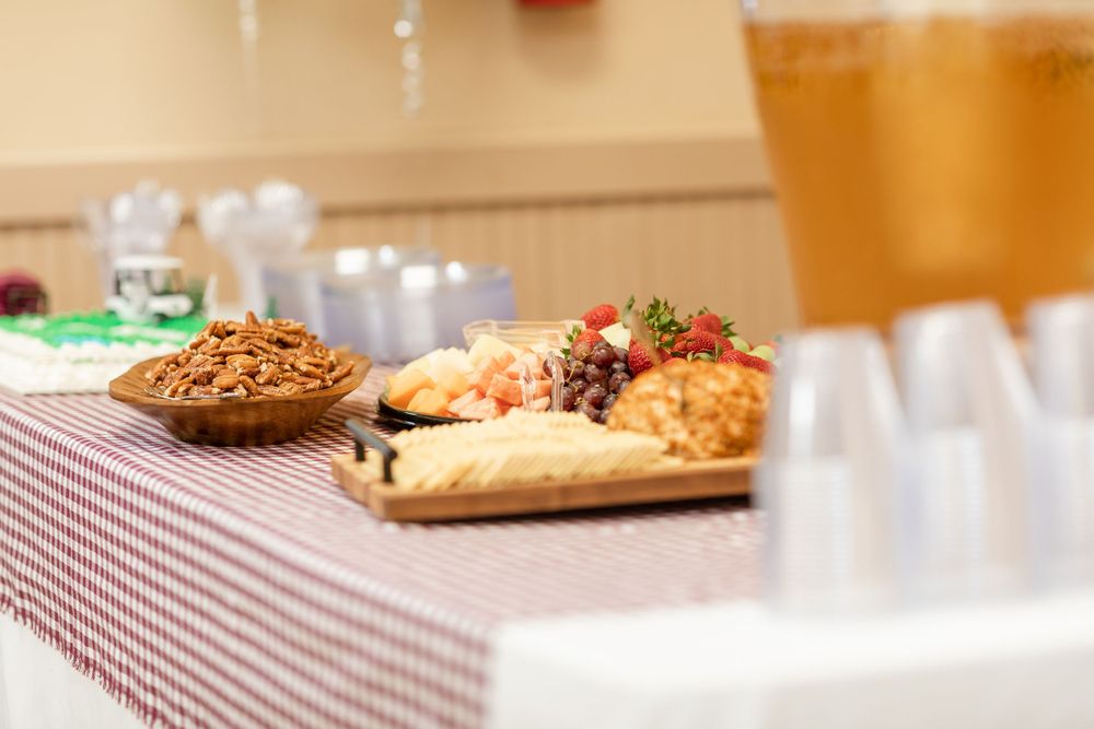 A dessert table with checkered tablecloth displays various treats and decorative elements.