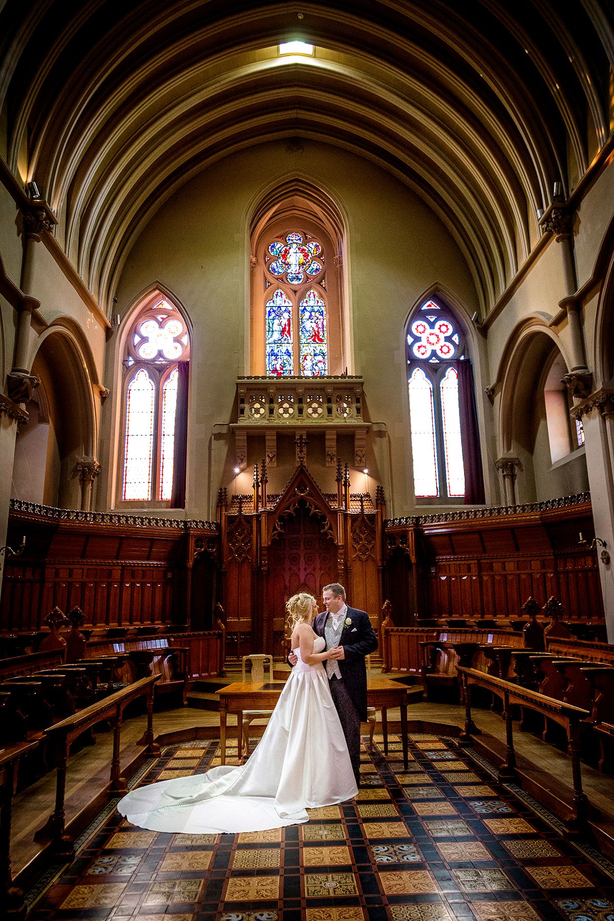 bride and groom in each others arms and starring into each otherrs eyes at the alter