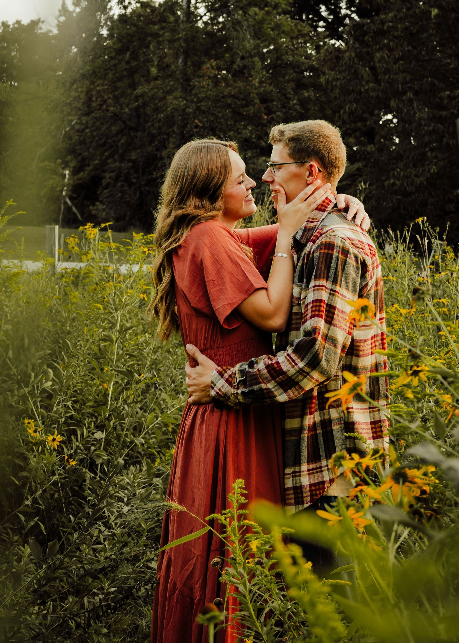 Couple embrace in flower patch at Holliday Park.