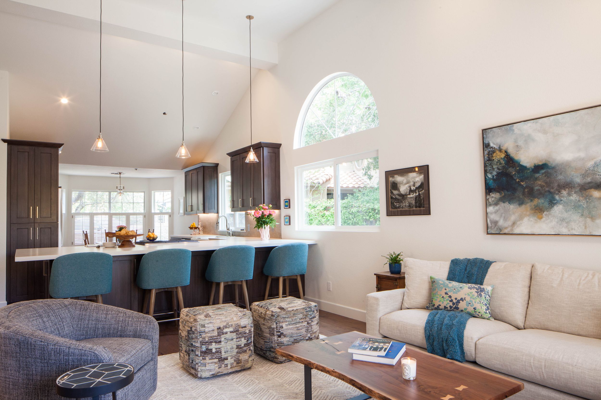 Contemporary open concept living room with blue accents and vaulted ceiling.