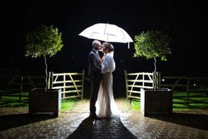 Bride and groom in the rain on their wedding day